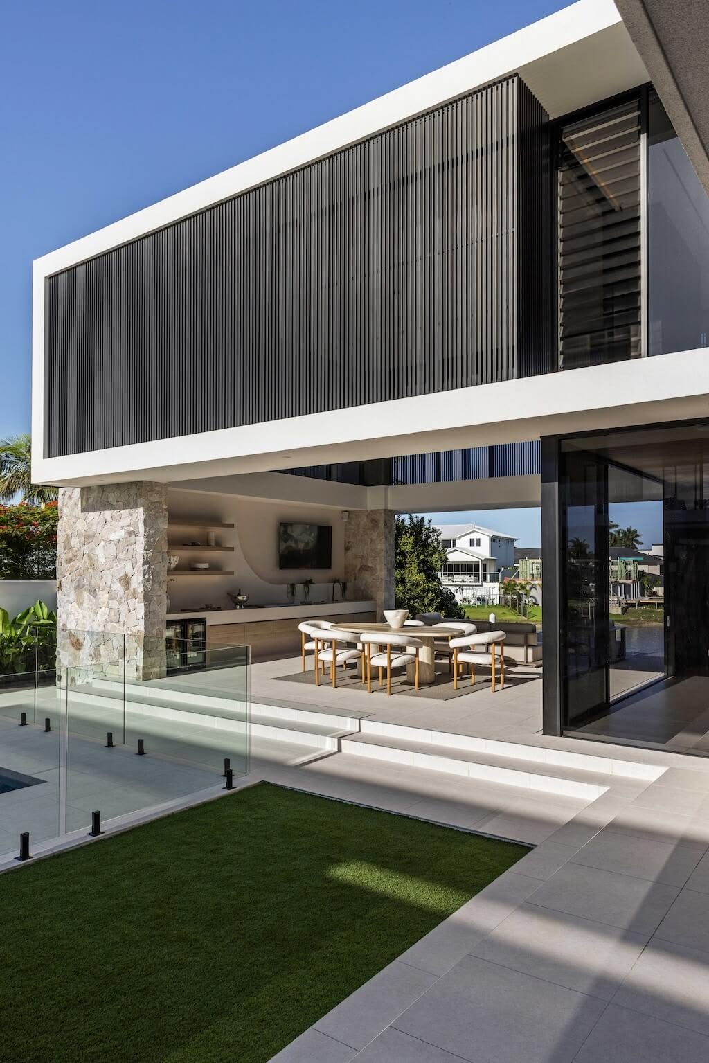 A contemporary Australian home at dusk with the alfresco lit and open to the garden